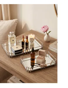 Luxe zilveren metalen spiegelplateaus met decoratieve parfum en kaarsen op tafel