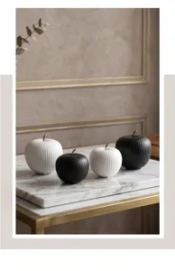 Detail of Nordic minimalist ceramic apple ornaments in black and white on marble