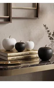 Macro view showing the ribbed texture of black and white ceramic apple ornaments.