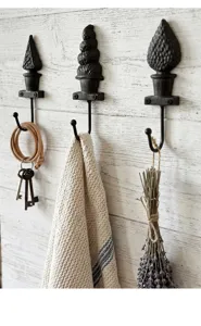 Vue détaillée de crochets muraux rustiques en fonte en forme de topiaire sur bois