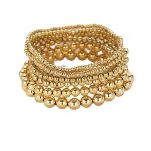 Set van goudkleurige kralenarmbanden in verschillende maten voor een trendy laagjeslook