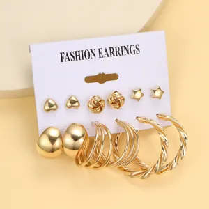 Detailansicht eines goldenen Ohrring-Sets mit Herz-, Stern- und Creolen-Designs auf Karte