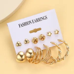 Detailansicht eines 6-teiligen goldenen Ohrring-Sets mit Herzsteckern und Creolen