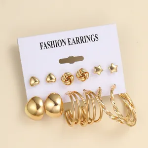 Detaillierte Makroaufnahme eines goldenen Vintage-Ohrring-Sets mit Herz- und Creolenstilen