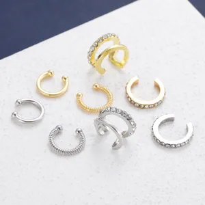 Macro view of assorted gold and silver rhinestone-encrusted C-shaped non-pierced ear cuffs