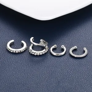 Detail view of four silver-toned ear cuffs with rhinestone and textured designs.
