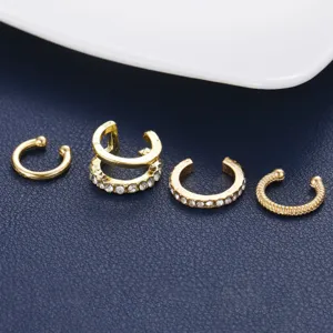 Detail view of 4-piece gold C-shaped ear cuff set featuring rhinestones and textured bands