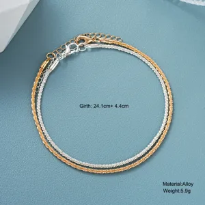 Detailed view of shimmering gold and silver layered anklets with size specs