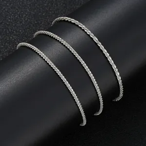 Macro detail of shimmering silver-tone minimalist beach anklet chain on black background