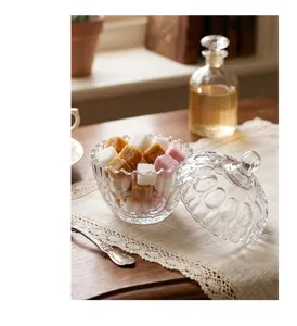 Detalle de un tarro de cristal en relieve sobre un mantel de encaje con terrones.