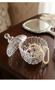 Primer plano de un joyero de cristal transparente con relieve de estilo francés y tapa