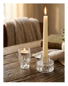 Nahaufnahme von Kerzenhaltern aus Glas mit Eisstruktur auf einem rustikalen Holztisch
