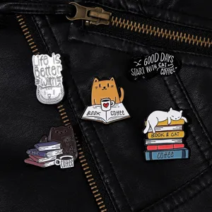 Makro-Detail von süßen Emaille-Pins mit Katzen- und Buchmotiven auf schwarzer Lederjacke
