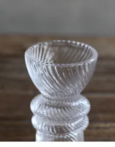 Λεπτομερής άποψη διαφανούς κηροπήγιου από ραβδωτό γυαλί με κομψή σπειροειδή υφή.
