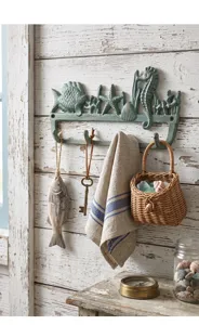 Detailansicht der mediterranen Gusseisen-Wandhaken mit Meerestieren an rustikaler Wand.