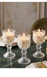 Romantisches Dinner-Setting mit drei tulpfenförmigen Glaskerzenhaltern und Kerzen.