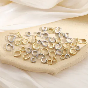 Detalle de varios pendientes con circonitas en acabado dorado y plateado en un plato de piedra