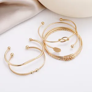 Set of 5 elegant gold-toned open cuff bracelets featuring varied creative geometric designs