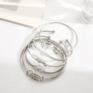 Detail view of 5-piece silver geometric cuff bracelet set with knot and bead designs