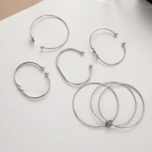 Macro view of 5-piece silver geometric knot and minimalist ball open bangle set
