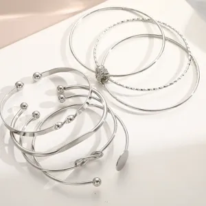 Close-up detail of a 5-piece silver minimalist geometric open knot bangle set for women