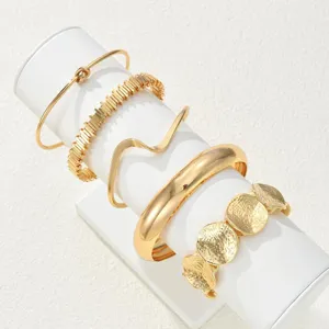 Detailed view of 5-piece vintage gold stackable bracelet set with textured patterns