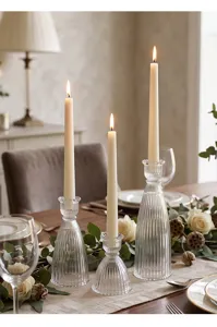Eleganti candelabri in vetro rigato su una tavola festiva con candele accese
