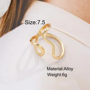 Close-up detail of irregular wavy gold-tone alloy open ring with minimalist design