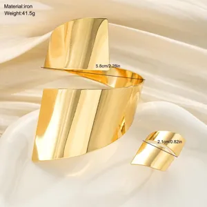 Macro di un set di bracciale e anello geometrici dorati con finitura metallica lucida