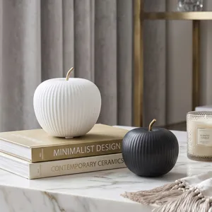 Nordic minimalist ceramic apple ornaments in black and white on marble tabletop