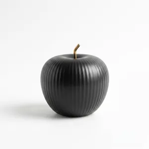 Modern Nordic matte black ceramic apple ornament with ribbed texture and gold stem