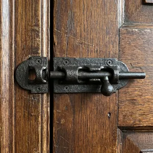 Antique rustic cast iron door bolt latch with textured finish for wooden gates and barn doors