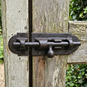 Antique rustic cast iron slide bolt latch for wooden gates and doors with a dark brown finish