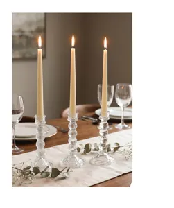 Juego de tres portavelas de cristal transparente de lujo en una mesa de comedor elegante