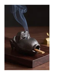 Detailansicht eines gusseisernen Affen-Räuchergefäßes mit aufsteigendem Rauch im Zen-Stil.