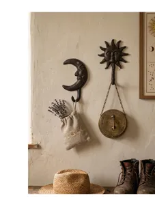 Patères murales vintage en fonte soleil et lune dans un décor rustique