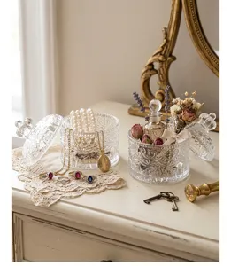 Close-up of vintage embossed clear glass jewelry storage box showing intricate floral patterns