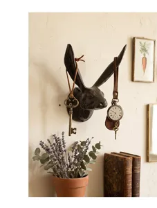 Detailweergave van rustieke gietijzeren konijnenkop muurhaak in een vintage setting