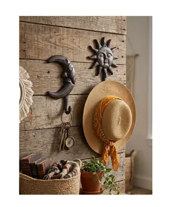 Crochets muraux décoratifs en fonte lune et soleil sur un mur en bois rustique