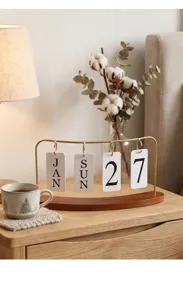 Calendrier perpétuel rétro en fer sur un bureau en bois confortable avec fleurs de coton