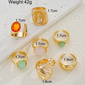 Detalle de cerca de un juego de anillos dorados bohemios con piedras de colores y tallas