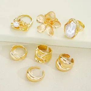 Detalle de anillos de nudillos chapados en oro con perlas y diseños florales