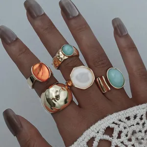Vista macro detallada del conjunto de anillos dorados vintage bohemios con piedras de colores