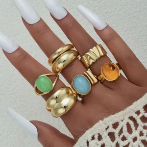 Detalle de un conjunto de anillos dorados de estilo bohemio con piedras de colores