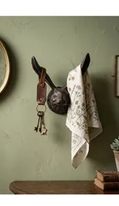 Rustieke gietijzeren konijnenkop muurhaak met sleutels en een bloemen handdoek decor