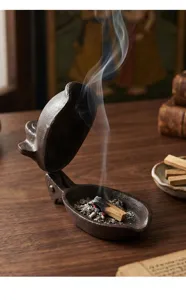 Detailansicht eines Vintage-Affen-Räuchergefäßes aus Gusseisen mit Palo Santo Rauch.
