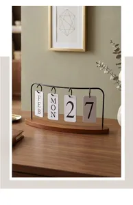 Calendrier perpétuel vintage en fer sur bureau en bois avec cartes de date suspendues