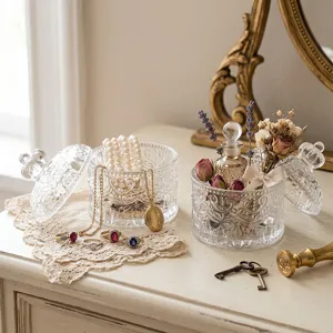 Two vintage Nordic style relief glass jewelry storage boxes on a white vanity table