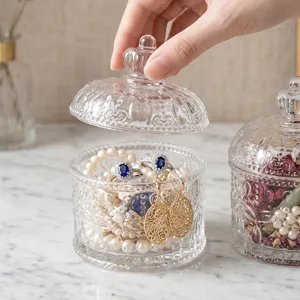 Elegant Nordic style embossed glass jewelry box with a crown lid handle on marble background