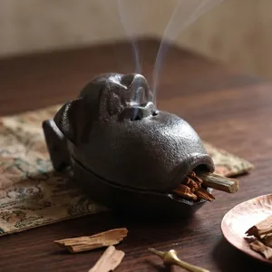 Retro Räuchergefäß aus Gusseisen in Affenkopf-Form mit Zen-Raucheffekt auf Holztisch